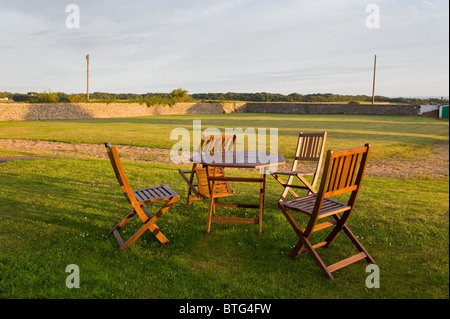 A hardwood patio set on the lawn in the warn rays of a summer sunset. Stock Photo