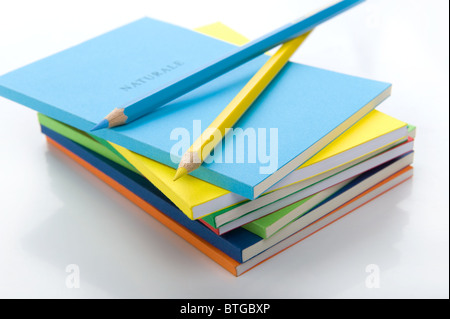 two colored pencils under the stack of books Stock Photo