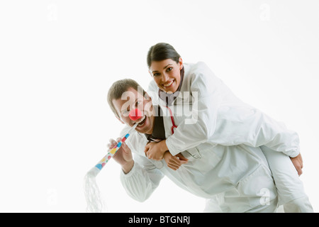 Male and female doctors playing with party toys Stock Photo