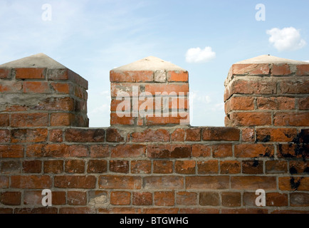 Photo of an ancient fence from a red brick Stock Photo