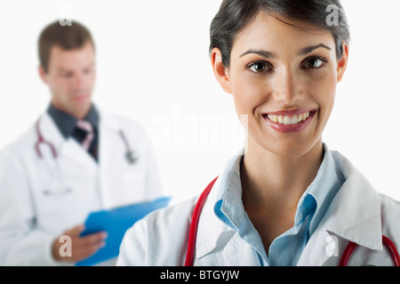 Doctor smiling and doctor reading medical chart Stock Photo