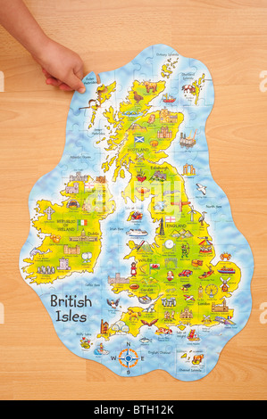A MODEL RELEASED child puts in the last piece of a jigsaw of the British Isles Stock Photo