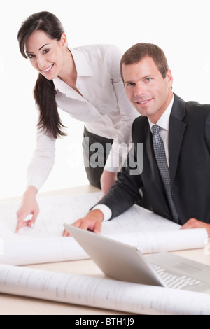 Man and woman looking over plans at desk Stock Photo