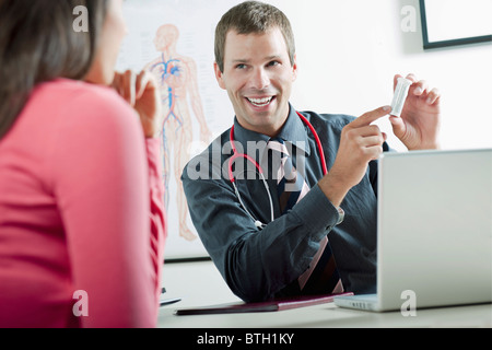 Doctor holding bottle of pills for patient Stock Photo