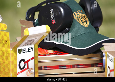 A set of ear defenders for safety at a clay pigeon range with a shooters cap and Eley cartridges ready to use. Stock Photo