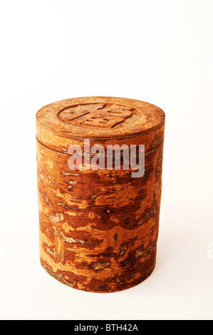 Vietnamese canister or box carved from cinnamon bark (Cinnamomum aromaticum) and marked with the Chinese character for luck. Stock Photo