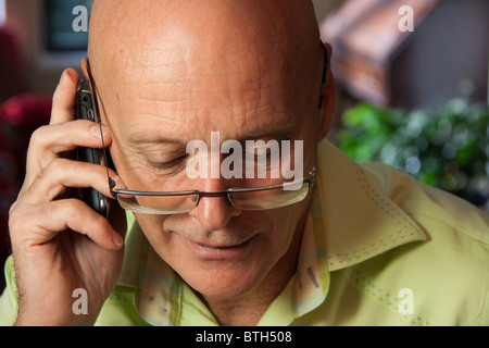 Bald man in eyeglasses talking on cell phone Stock Photo
