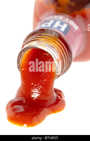 Bottle of HP seriously hot red chilli and honey sauce pouring onto a white surface Stock Photo