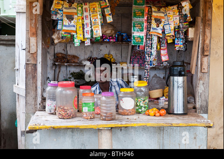 Indian village boy selling items from shop / stall in Puttaparthi, Andhra Pradesh, India Stock Photo