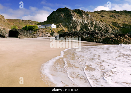 View from the beach and surf towards the waterside cafe at Kynance Cove, Cornwall Stock Photo