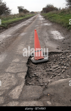 Pothole in road marked with traffic cone Stock Photo