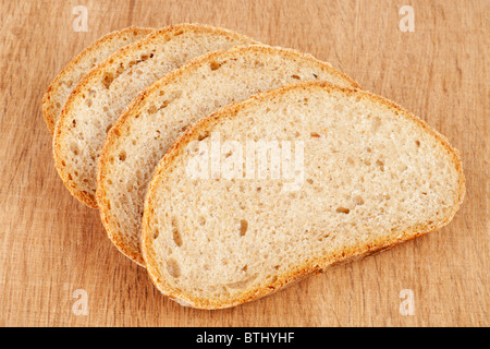 Fresh bread slices on a wooden cutting board Stock Photo
