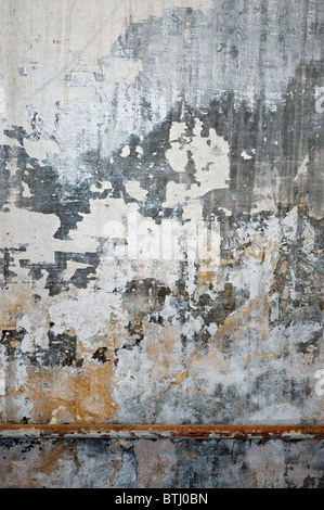 Old grungy wall texture. Peeling stained surface background. Stock Photo