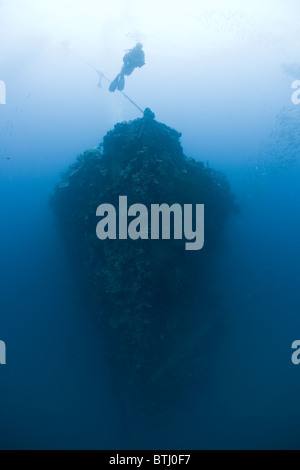 A diver hovers over the bow of the Iro, a huge Japanese tanker sunk during WWII in the protected lagoon of Palau. Stock Photo