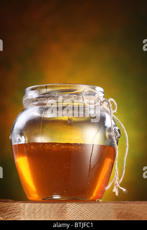 Pot of honey on a wooden table. Stock Photo