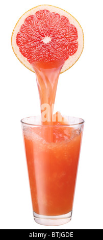 Juice flowing from cut grapefruit into the glass. Stock Photo