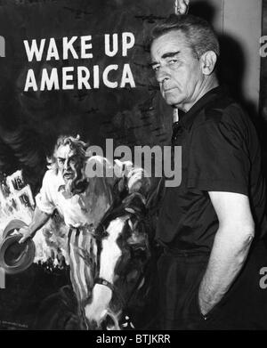 American artist and cartoonist James Montgomery Flagg stands next to his poster for the Wake Up America Committee, in his New Yo Stock Photo