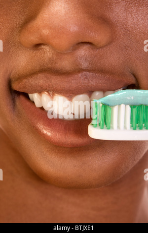 Close up of Afro-American female brushing her teeth Stock Photo