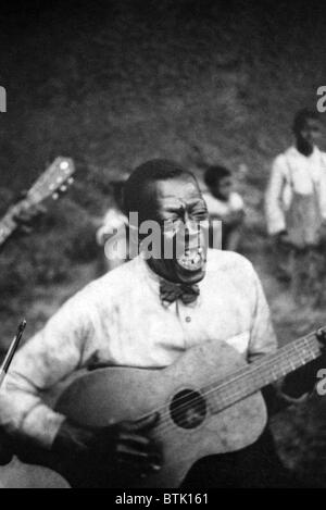 Stavin' Chain (Wilson Jones), Blue Singer, playing guitar and singing the ballad 'Batson,' Lafayette, Louisiana. 1934 Stock Photo