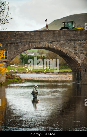 Autumn afternoon - a fisherman fly fishing for trout in the River Wye at Builth Wells , Powys Wales UK Stock Photo