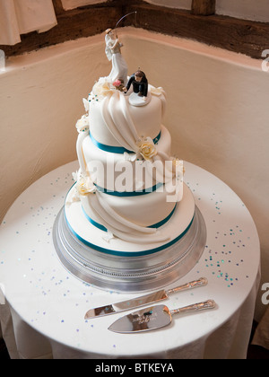Wedding cake top decoration of bride 'catching' groom Stock Photo