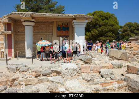 Visitors look at the Procession Fresco at South Propylaeum in Knossos Palace, showing an ancient ceremonial cult procession. Crete, Greece. Stock Photo