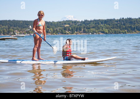boy and girl on paddle board Stock Photo