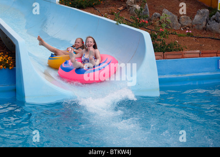 Mother and daughter water sliding on balloons together in Acqua Plus Water park. Crete, Greece. Stock Photo