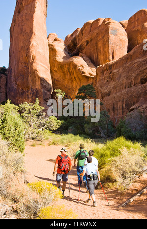 Visitors hike on the Devils Garden Trail in Arches National Park. Stock Photo