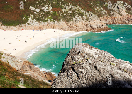 A rock provides foreground interest in view from clifftops over Porthcurno beach, Cornwall Stock Photo