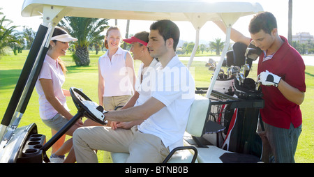 Golf course young team people group buggy green grass field Stock Photo