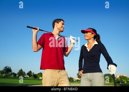 Golf course young happy players couple talking posing on bunker Stock Photo
