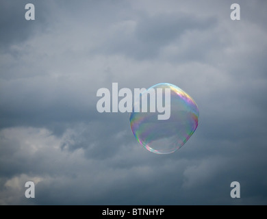 Soap bubble floating against a cloudy and stormy sky Stock Photo