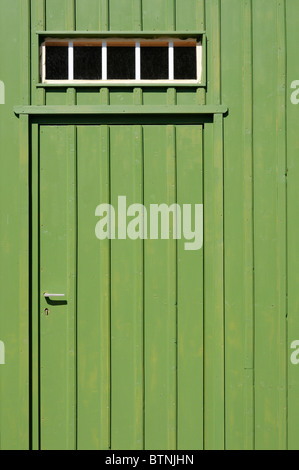 Eingang mit grün gestrichener Brettertür und Oberlicht. - Entrance with green painted batten door and transom window. Stock Photo