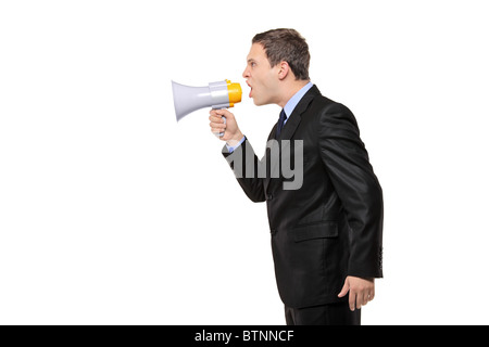 An angry businessman announcing via megaphone isolated against white background Stock Photo
