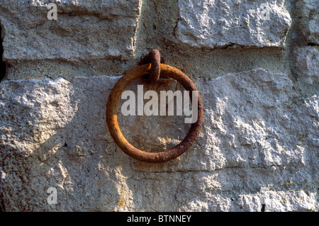 Rusty mooring ring set in a stone wall at Kimmeridge, Dorset Stock Photo