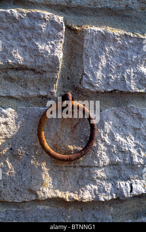 Rusty mooring ring set in a stone wall at Kimmeridge, Dorset Stock Photo