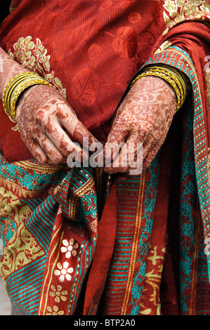 Indian girl wearing traditional silk sari with henna hands. India Stock Photo