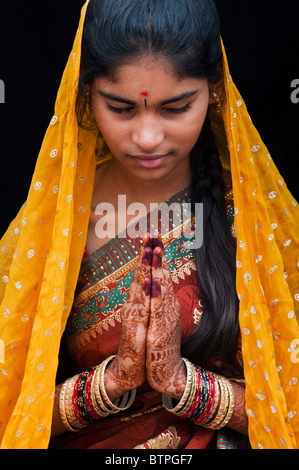 Indian girl wearing traditional silk sari with henna prayer hands. India Stock Photo