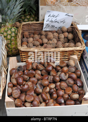 A box of chestnuts and basket of walnuts on a market stall in Clifton, Bristol. Stock Photo