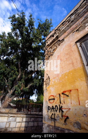 Crumbling facade of an old building marked with graffitis in Ermoupolis, on the Greek Cyclade island of Syros. Stock Photo