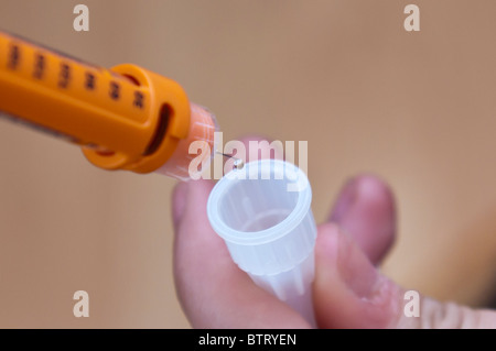 Young diabetic girl prepares an injection of insulin to treat diabetes type one Stock Photo