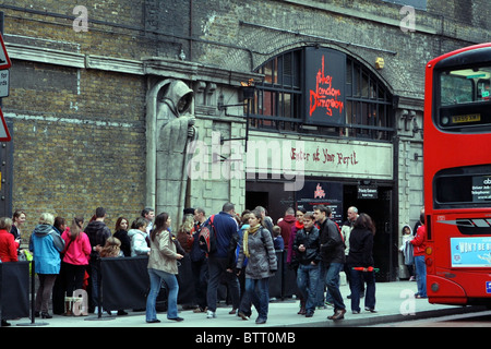 A queue waiting to enter the London Dungeon near London Bridge, with the back of a London bus on the right of the image Stock Photo