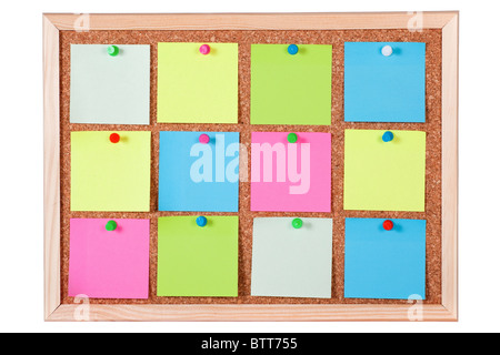 Pieces of blank colorful note papers on a cork bulletin board, isolated on white background. Stock Photo