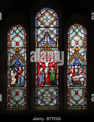 A stained glass window depicting The Crucifixion and jesus reviving the dead, Church of St James, North Newnton, Wiltshire Stock Photo