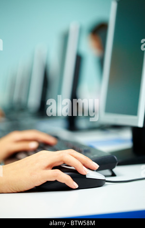 Image of female hand on mouse while typing on keyboard in a working environment Stock Photo