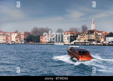 A 'Grazia' boat speeds across the bay towards St Mark's / San Marco Square Venice Italy Stock Photo