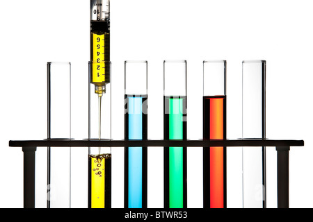Row of test tubes filled with colored fluid, syringe filling one test tube. Stock Photo