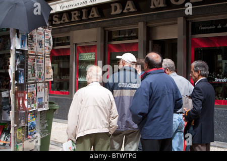 Men reading news headlines Lisbon Portugal Stock Photo