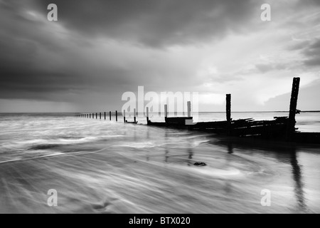 battered sea defences suffer furthermore during a springtime storm at The Warren, Folkestone, Kent Stock Photo